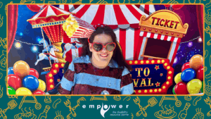 Empower N L Board Member Mandy Penney poses in front of the carnival wall, with her popcorn headband costume. The Empower N L logo is centered at the bottom.