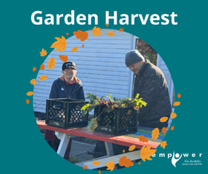 Empower N L members work at a picnic table sorting the results of their Garden Harvest. The Empower N L logo is in the lower right corner.